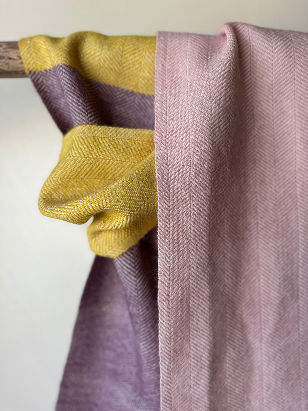 Folded yellow, pink and purple fabric on a wooden surface