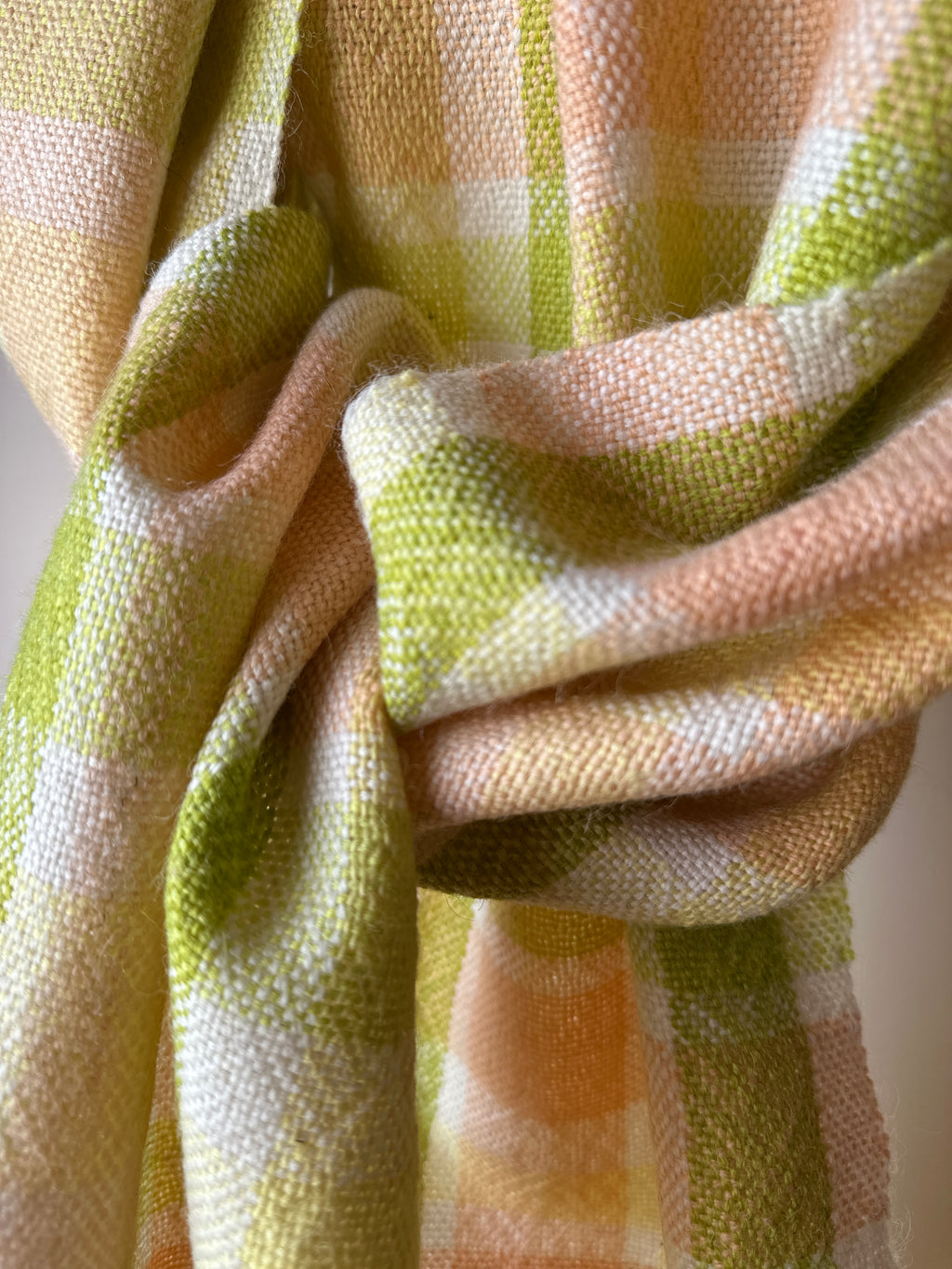 Close-up of checkered scarf with green and orange pattern